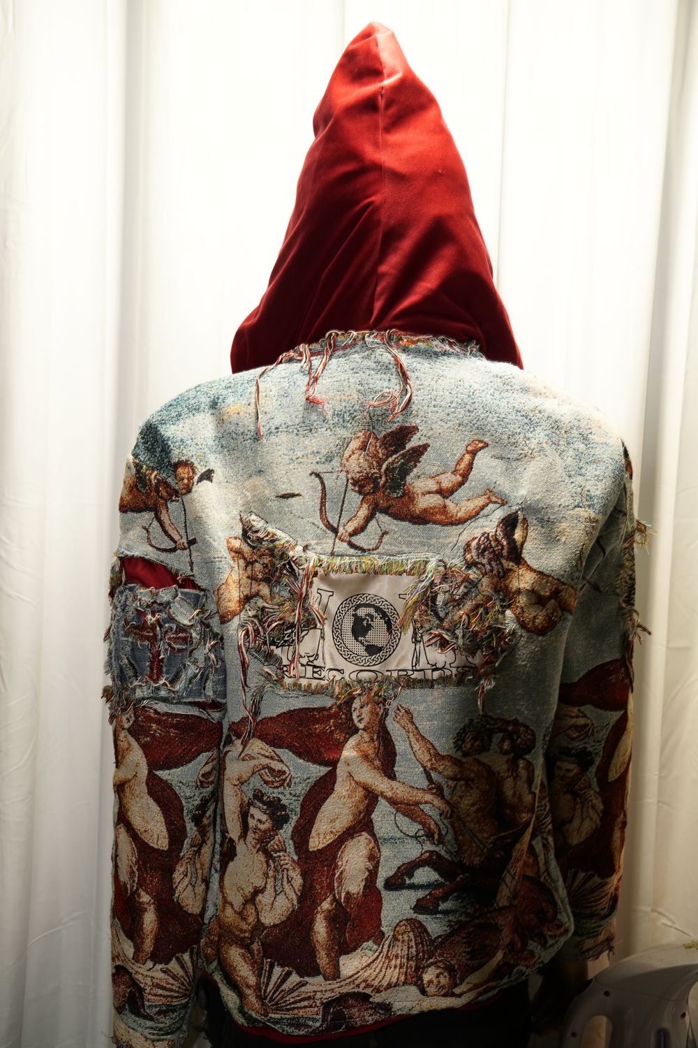 One-of-one reworked denim jacket with baroque tapestry fabric, red velvet hood, and a Heaven or Hell Records woven label on the back