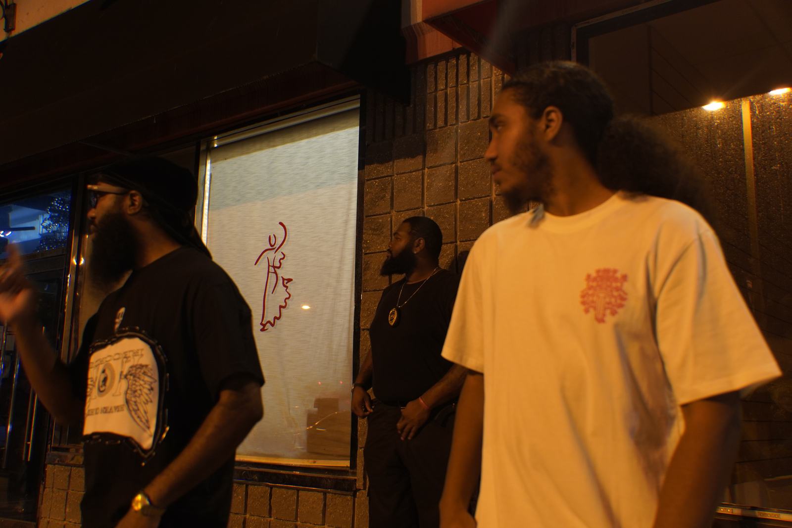 Group wearing Heaven or Hell Records tees outside a storefront at night, part of the Heaven or Hell family