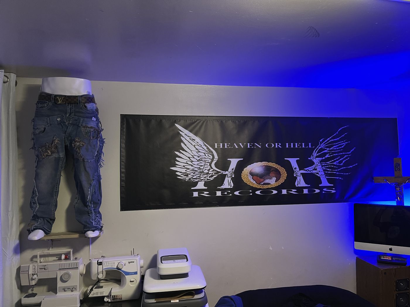 Custom cross-patch denim hanging beside the Heaven or Hell Records studio banner
